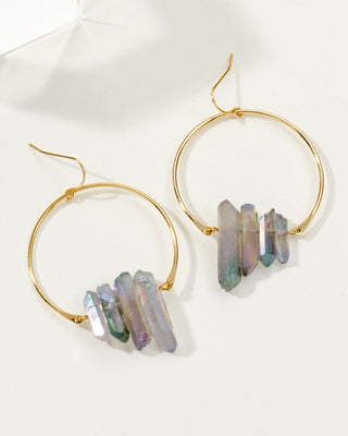 Pair of Rainbow Quarts Supernova earrings with gold hoops on a white tabletop.