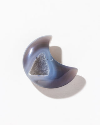 Druzy agate crescent moon curio on a white background.