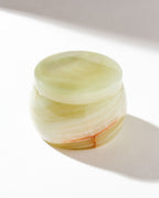 Rounded calcite jewelry box sitting on a white surface.