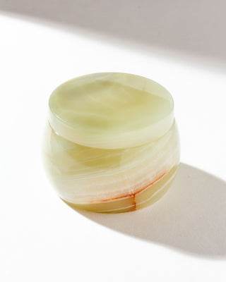 Rounded calcite jewelry box sitting on a white surface.