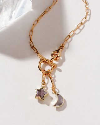 A gold-colored toggle necklace with paperclip-style chain and dangling coffee moonstone star and crescent-shaped charms, displayed against a white background.