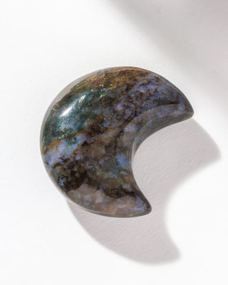 Moon shaped ocean Jasper gemstone curio against a white backdrop