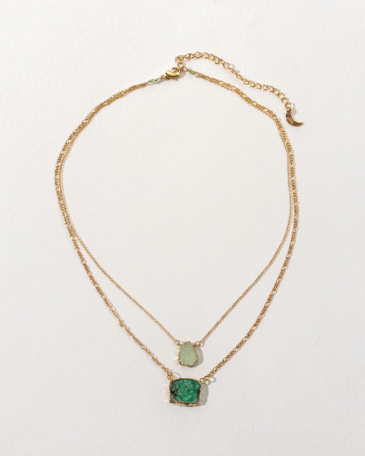 Emerald Sea Layered Necklace featuring green gemstones on a gold chain.