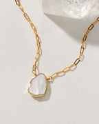 Gold chain necklace with a Mother of Pearl pendant.
