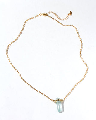 Gold necklace with a quartz pendant on a white background