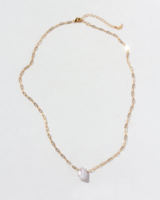 Gold chain necklace with a pearl pendant on a light gray background