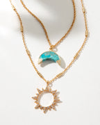 Gold necklace set with a turquoise crescent moon and sunburst pendant.