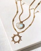 Two gold layering necklaces, one with moonstone heart and other with CZ sun pendants