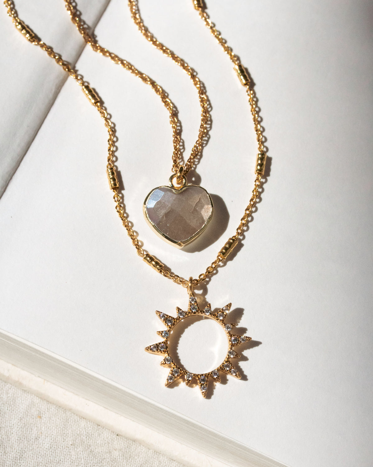 Gold necklace set with coffee moonstone heart and clear CZ sun charm pendant.