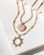 Gold necklace set with rose quartz heart and clear CZ sun charm pendant.
