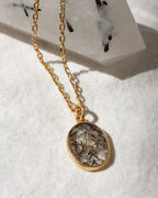 Necklace with a oval pendant on a white fabric background