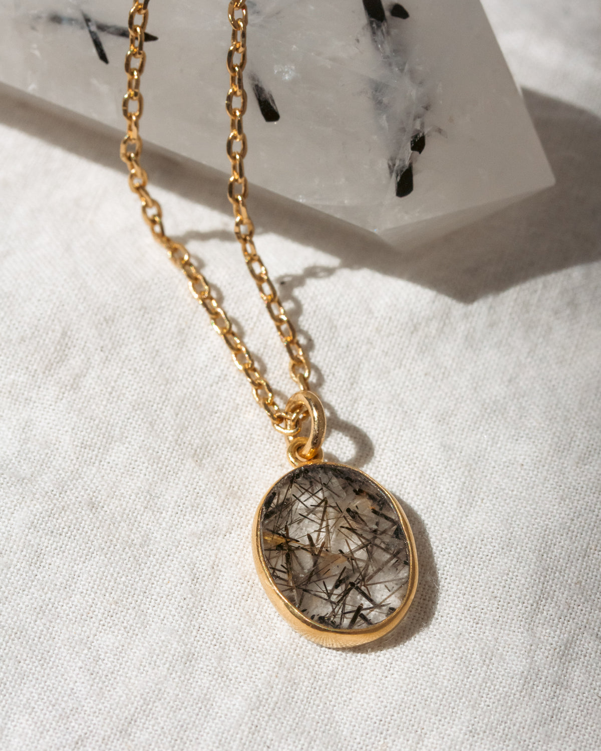 Necklace with a oval pendant on a white fabric background