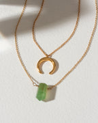 Gold necklaces with a green aventurine point and crescent moon charm.