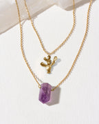 Gold layering necklaces with a purple amethyst and gold prickly pear cactus pendants