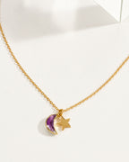 A delicate gold chain necklace featuring a amethyst crescent moon and star pendant.