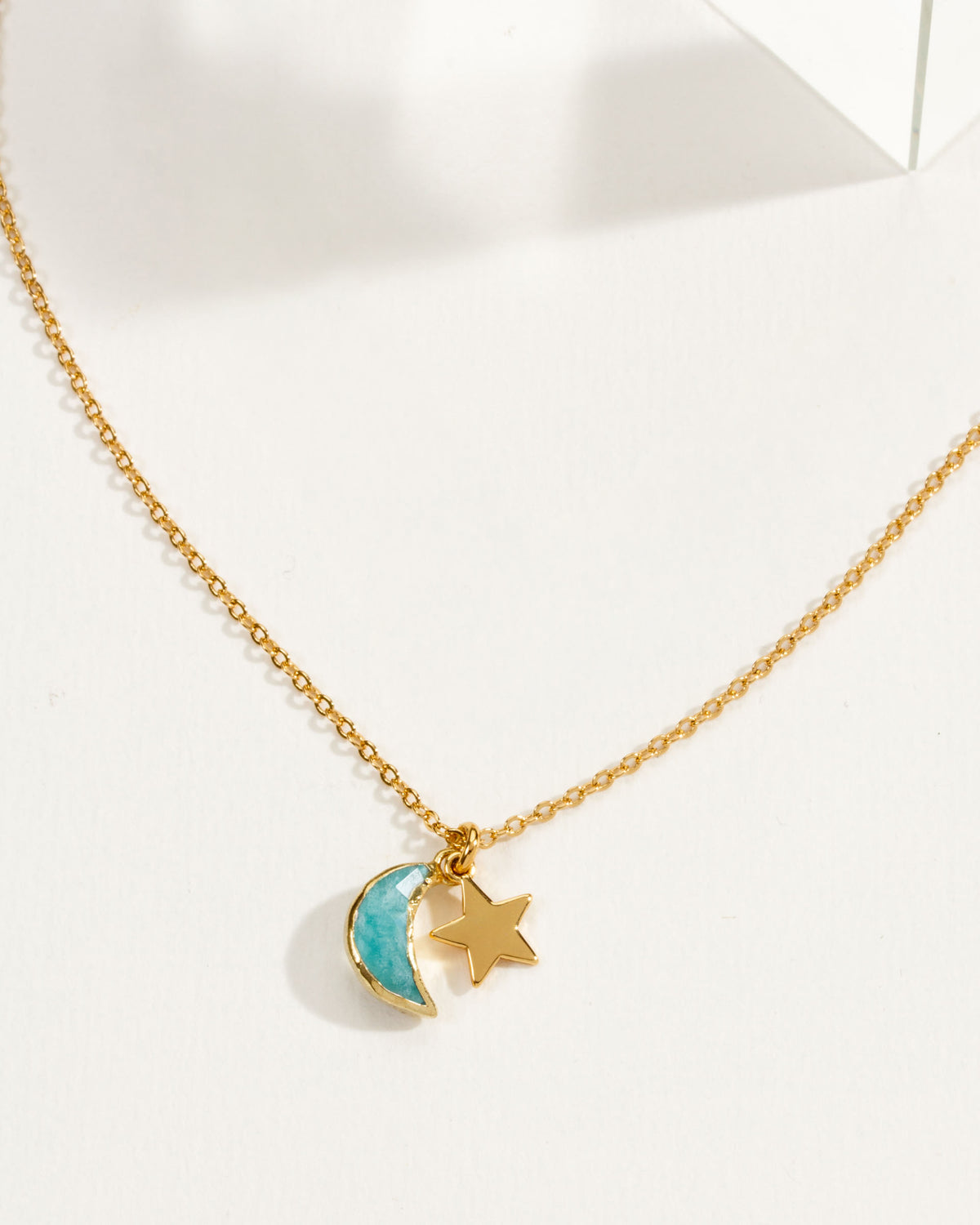 A delicate gold chain necklace featuring a amazonite crescent moon and star pendant.