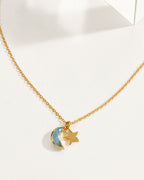 A delicate gold chain necklace featuring a aquamarine crescent moon and star pendant.