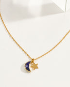 A gold chain necklace featuring a sapphire crescent moon and star pendant.
