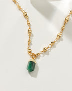 Gold necklace featuring an emerald point pendant.