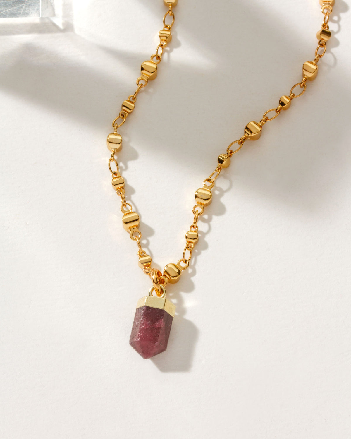 Straight To The Point Necklace with a Ruby gemstone and gold chain.