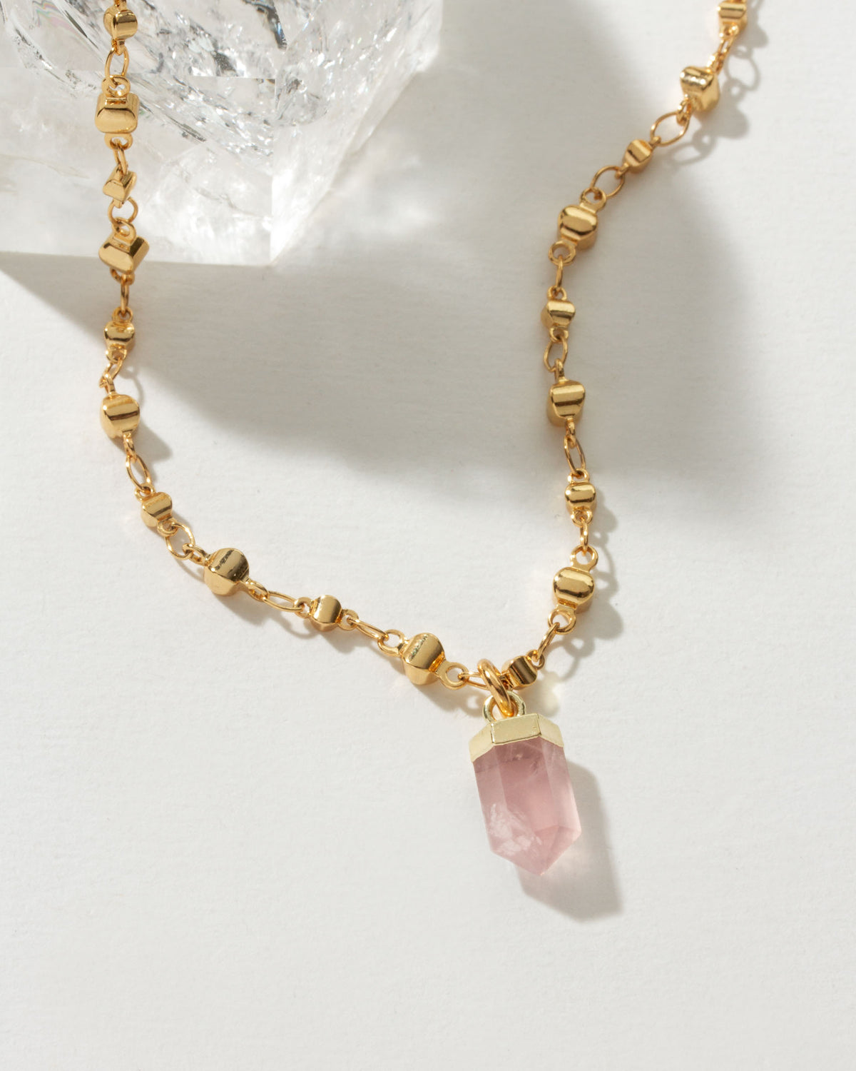 Gold necklace featuring a Rose Quartz point pendant.