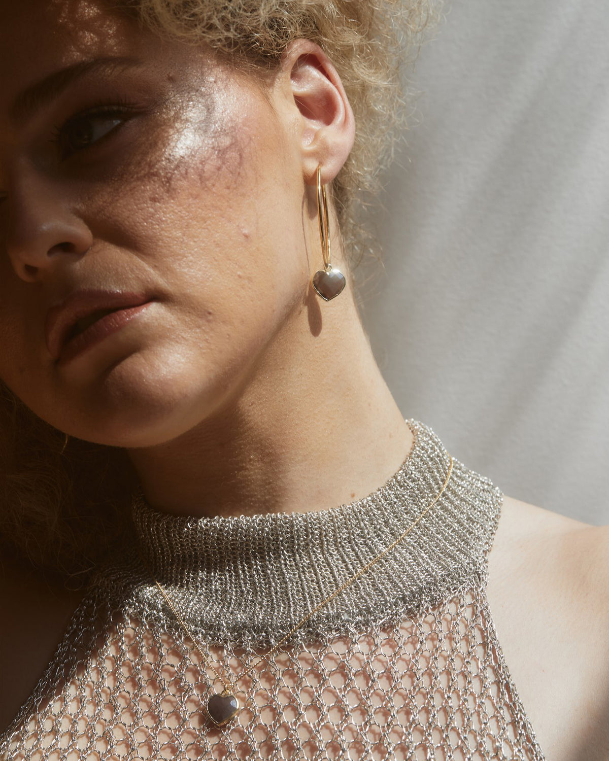 Model wearing coffee moonstone heart necklace.