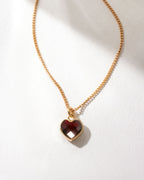 Gold dainty necklace with faceted garnet heart charm.
