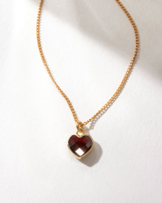 Gold dainty necklace with faceted garnet heart charm.