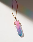 Necklace with a pink and blue crystal pendant on a white background