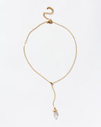 A Prism Point Lariat necklace with a clear quartz pendant and adjustable gold chain.