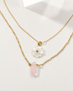 Layered gold necklaces with mother-of-pearl daisy and pink gemstone pendants