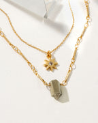 Gold necklaces featuring a sun star charm and a Pyrite gemstone.