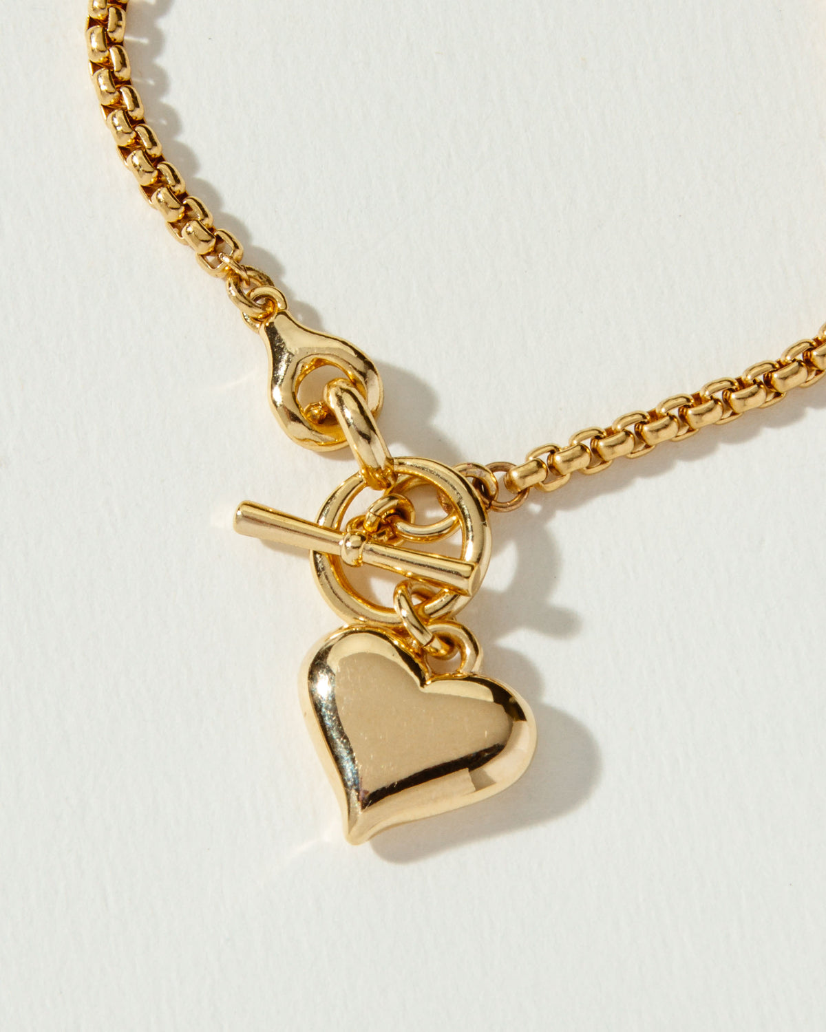 Gold popcorn-style chain necklace with a heart pendant and toggle clasp.
