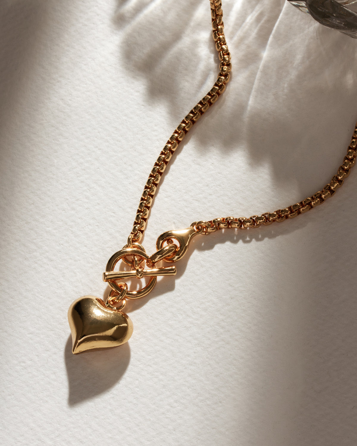 Gold popcorn chain necklace with toggle clasp and puffy heart pendant.