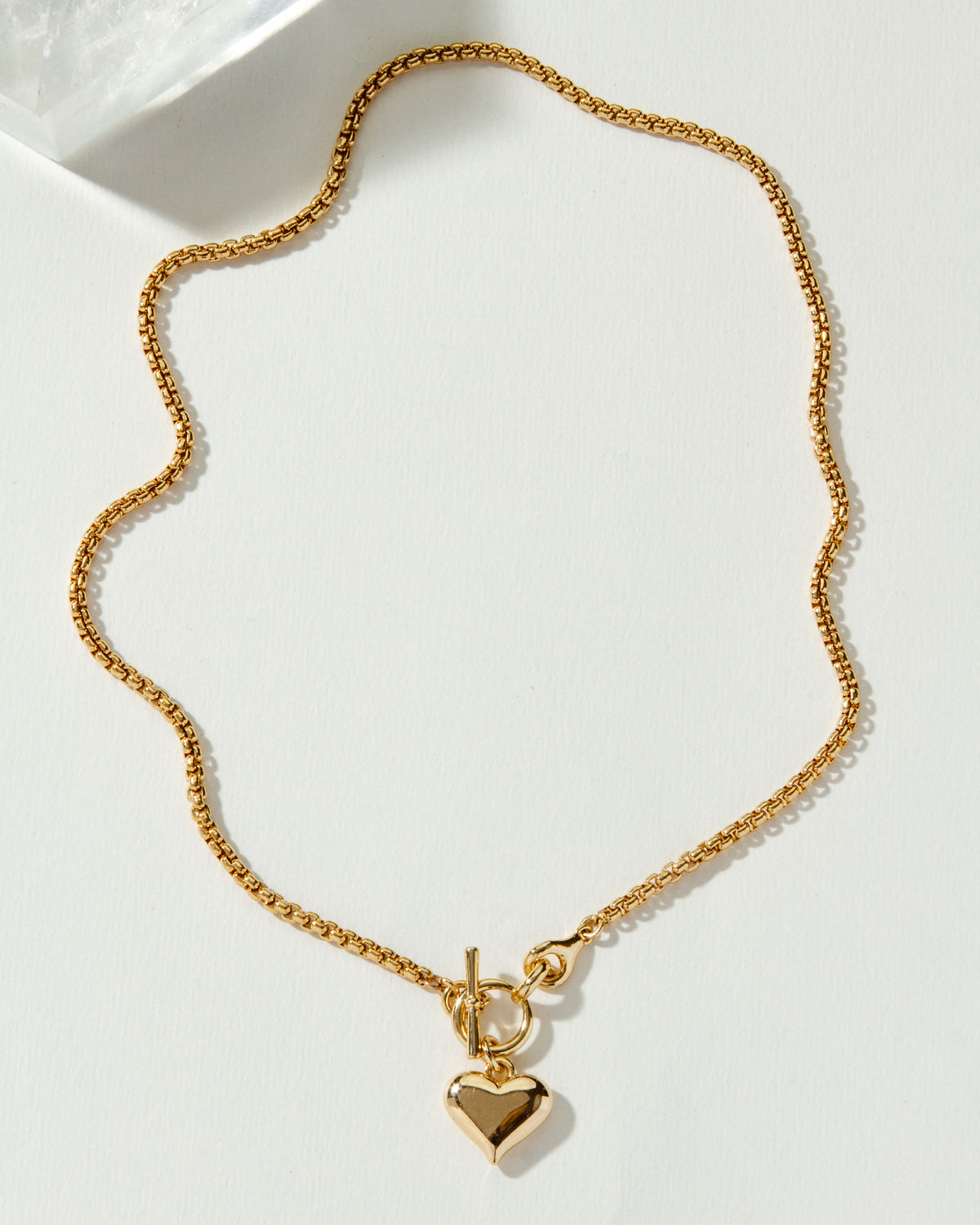 Gold popcorn chain necklace featuring a toggle closure and puffy heart pendant.