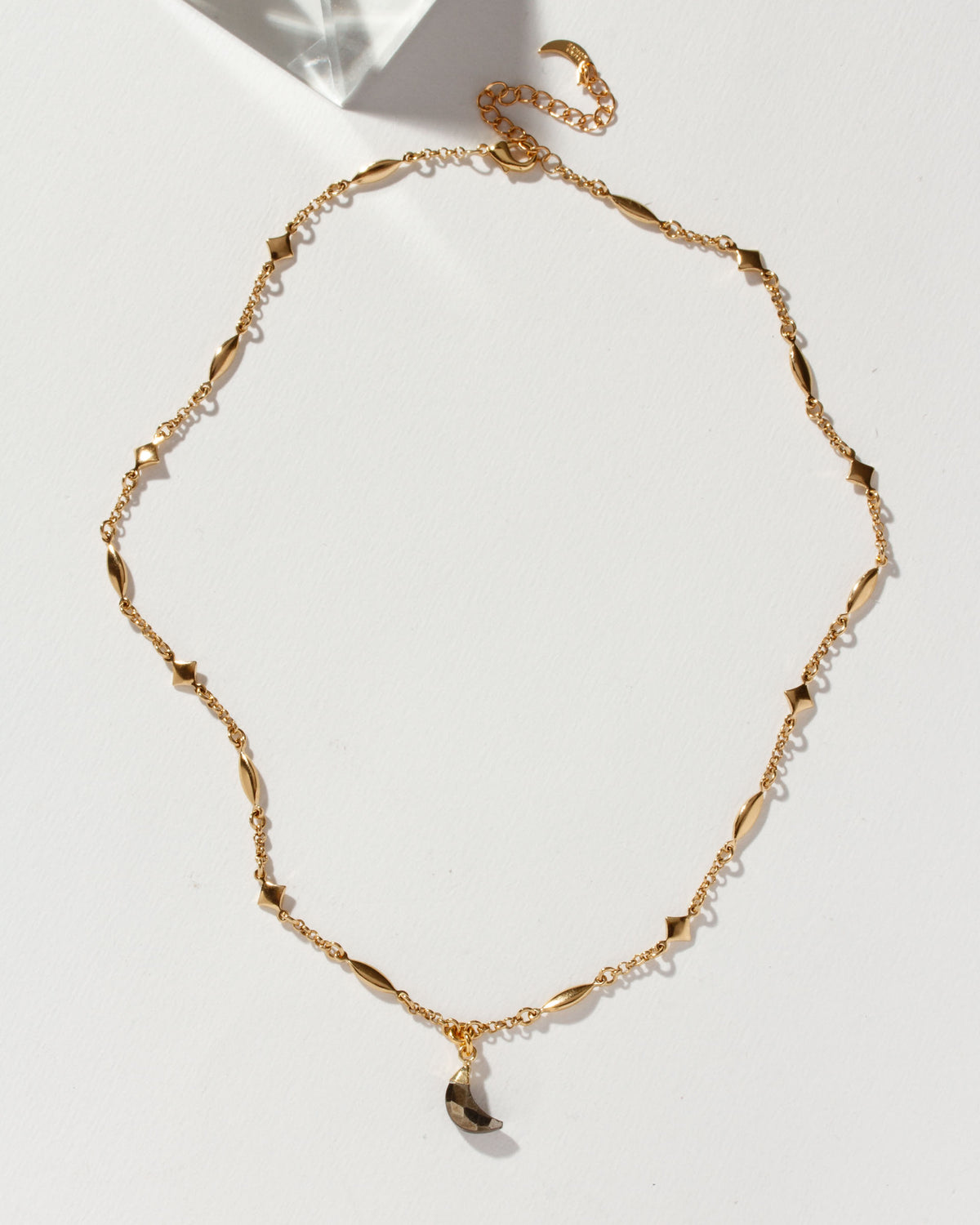 Dolce Luna necklace with a pyrite gemstone crescent on a gold chain.
