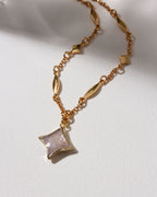 Gold celestial chain necklace with gemstone Polaris shaped charm.