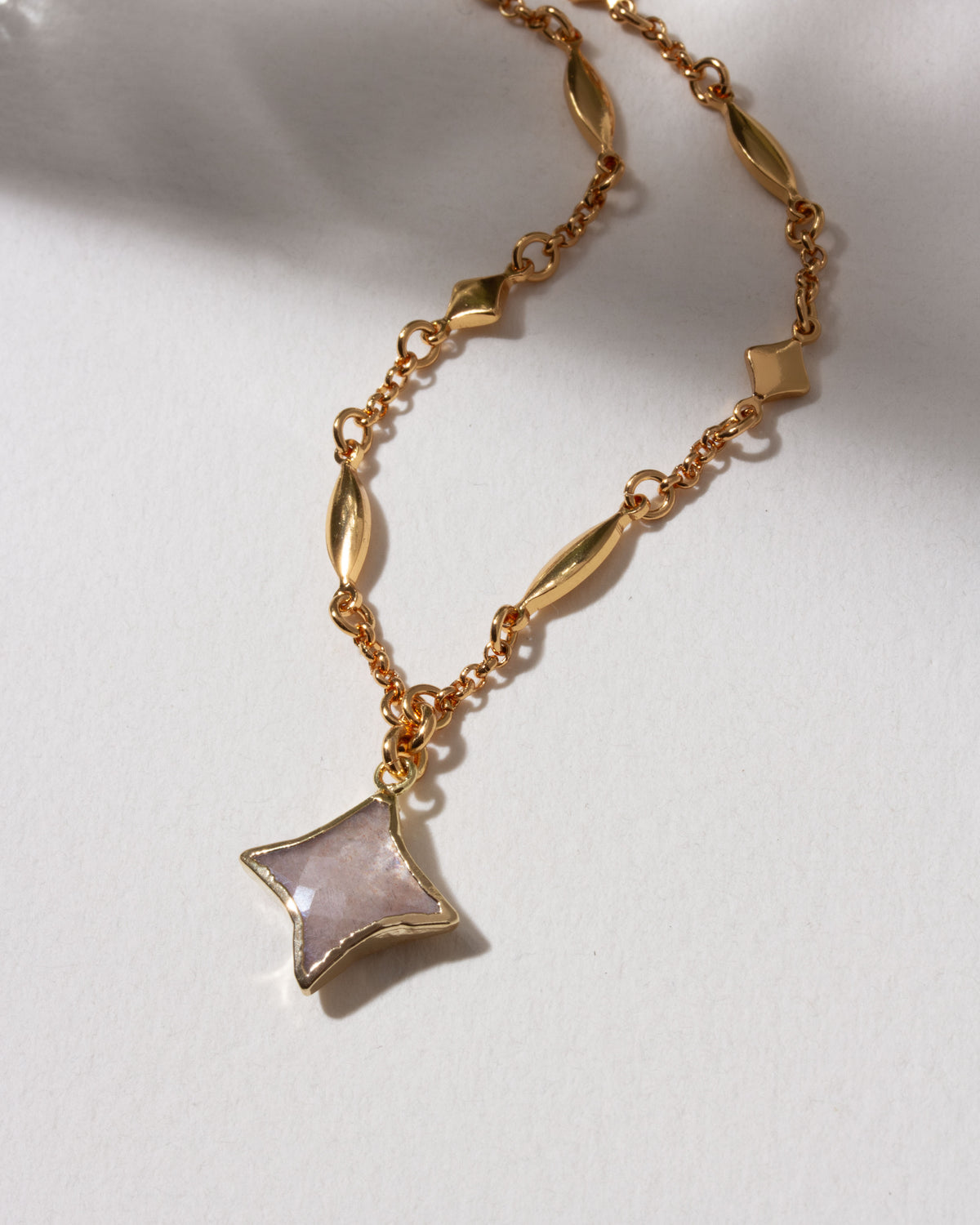 Gold celestial chain necklace with gemstone Polaris shaped charm.