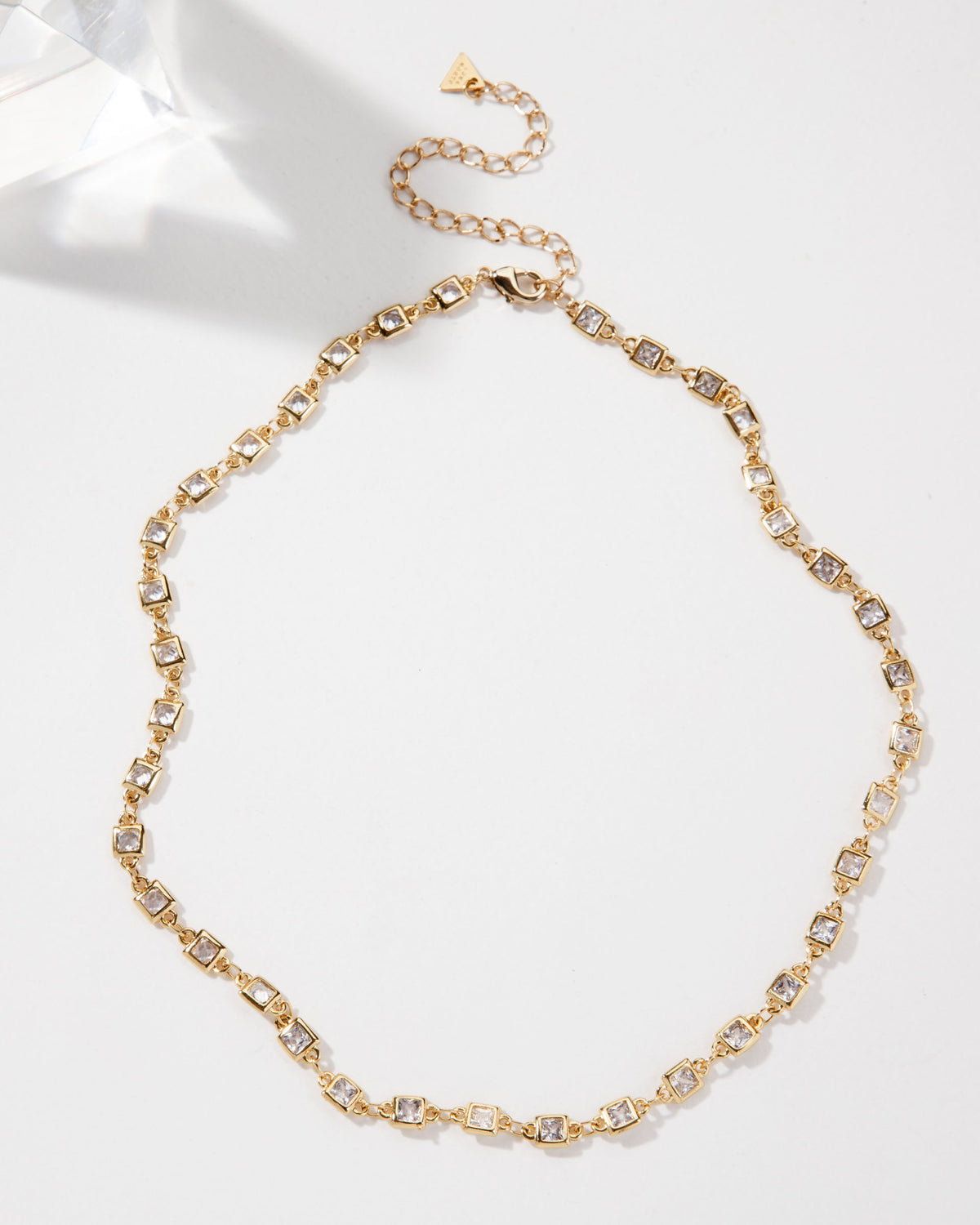 Gold collar necklace featuring square CZ stones, complete with an adjustable chain.