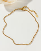 Gold-toned Tubular Popcorn Classic Chain with lobster clasp on a white surface.