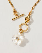 Golden Tulum Flora Toggle Necklace with a Mother of Pearl flower and CZ center.