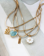 Gold necklaces with "wife" and "2026" and other pendants.