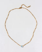 Gold chain necklace with a Blue Topaz gemstone pendant.