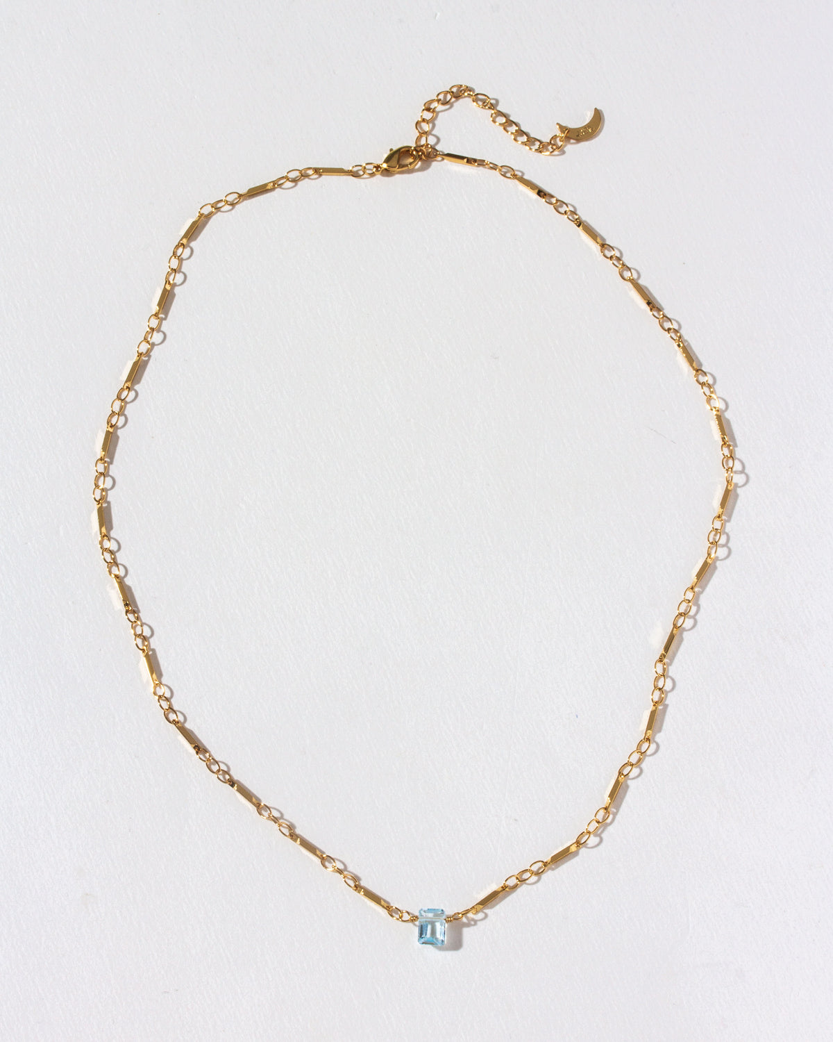 Gold chain necklace with a Blue Topaz gemstone pendant.