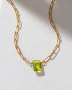 Gold chain necklace with a Peridot gemstone pendant.