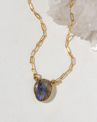 Gold chain necklace with a Labradorite pendant on a light background