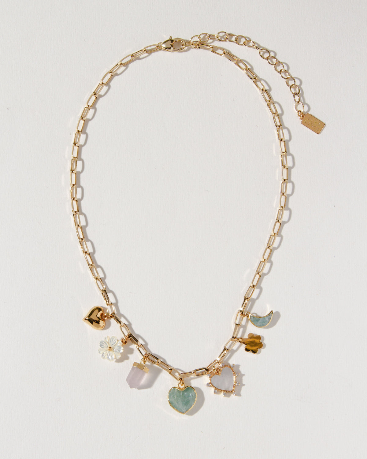 Gold charm necklace with mother-of-pearl, rose quartz, and aquamarine gemstones.