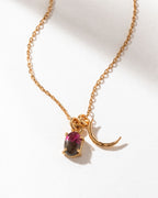 Gold chain necklace with a watermelon tourmaline gemstone and gold crescent moon charm.