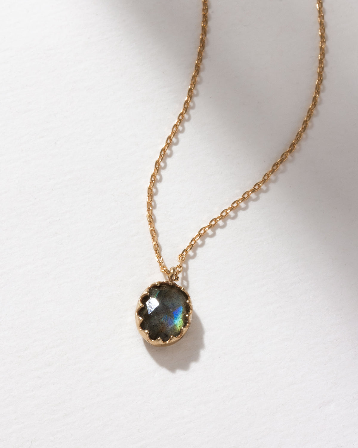 Neptune's Orbit Pendant Necklace with a faceted labradorite gem on an adjustable length gold chain.