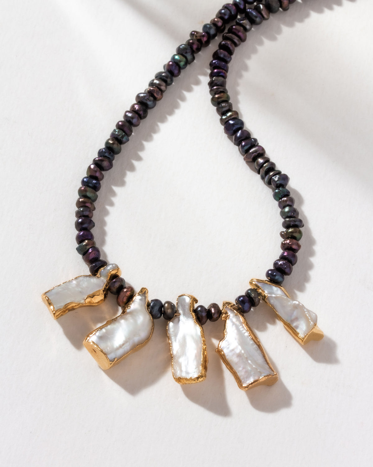 Freshwater pearl necklace with gold-plated keshi pearls and navy hue beads.